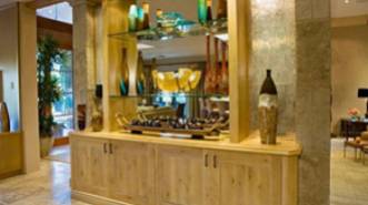 A room with wooden cabinets and glass shelves.