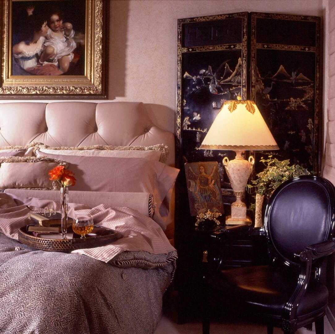 A bedroom with a bed, table and chair.