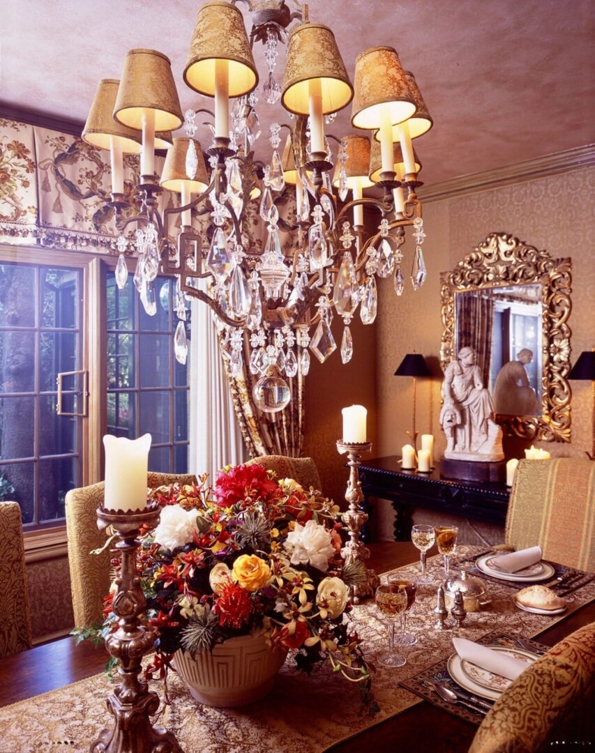 A dining room table with flowers and candles on it.