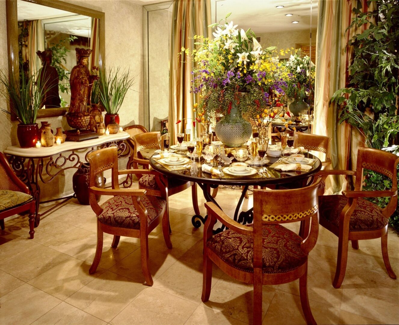 A dining room table with chairs and a vase of flowers.